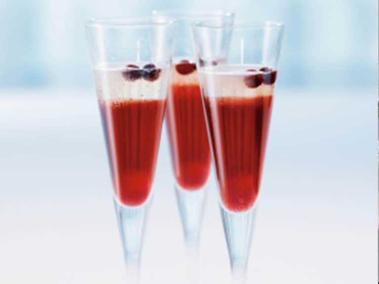 Three champagne flutes filled with Champagne Cocktail