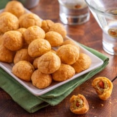 white platter holding Olive Cheese Balls, in front of two martinis