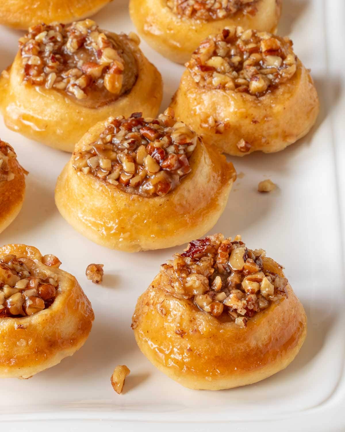 close up of a white platter holding mini pecan rolls