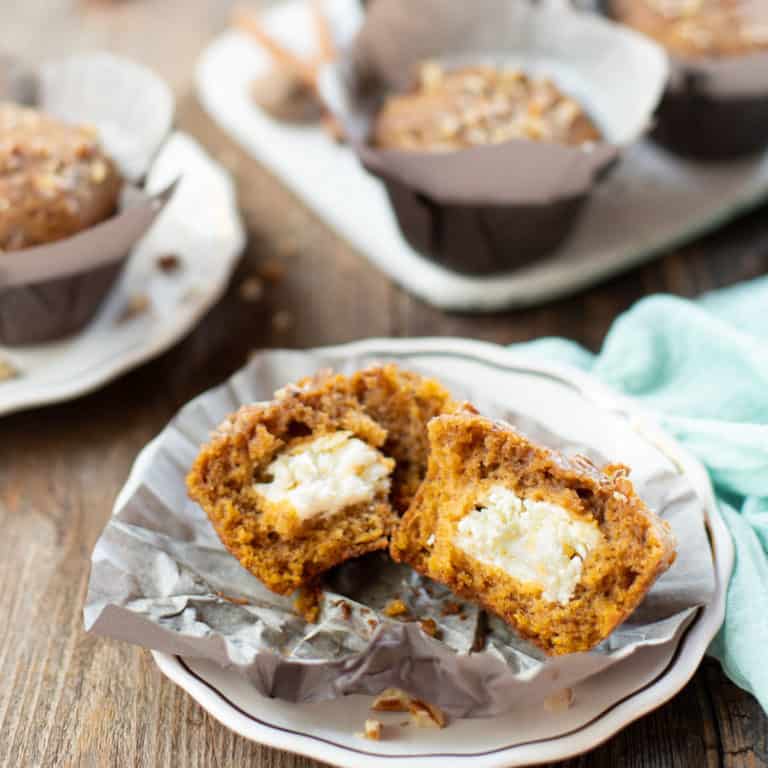 Pumpkin muffins, one broken half to show cream cheese filling