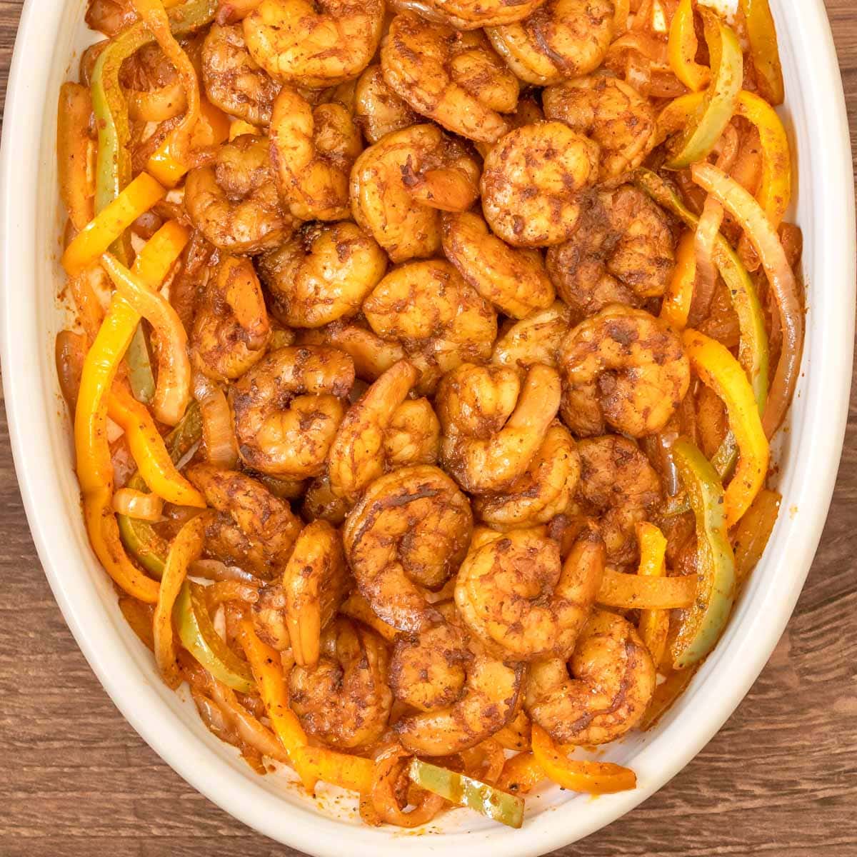 Overhead, close up shot of shrimp fajitas on a white platter